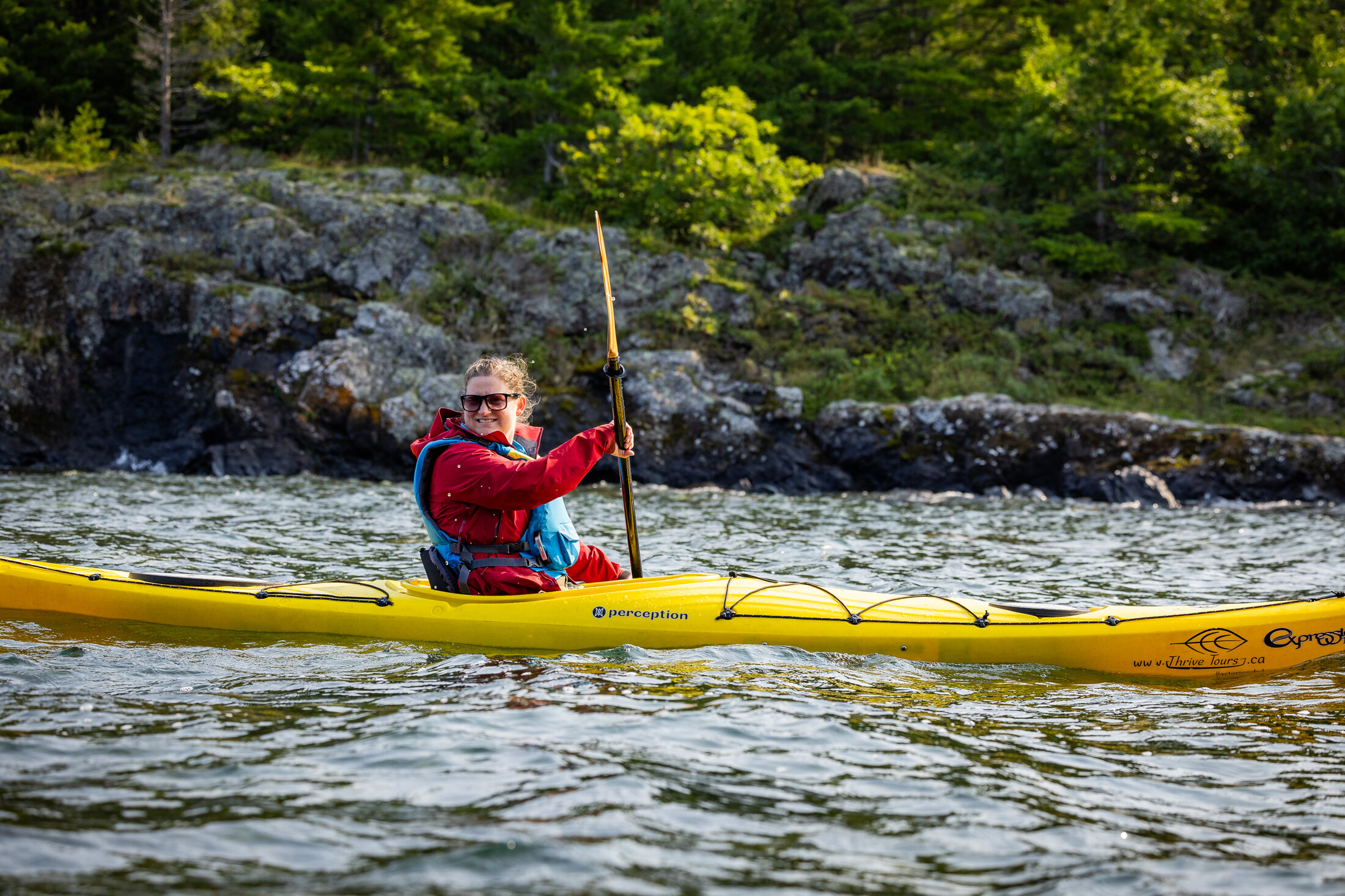 A smiling Thrive Tours paddler on Northern Ontario water